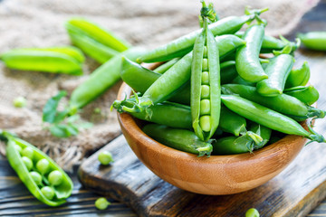 Wall Mural - Green peas in wooden bowl.