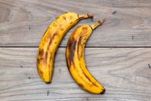 Two Fully Ripe Bananas On Top Of A Wooden Table