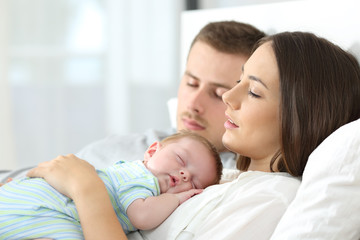 Wall Mural - Tired parents sleeping with their baby