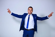 Young Successful Businessman With Raised Arms Standing On White Background. Business, People And Office Concept