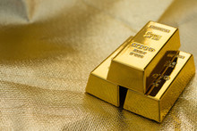 Three Pieces Of Gold Bars On A Golden Background