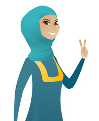 Wall Mural - Young muslim businesswoman showing victory gesture