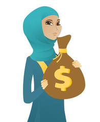 Wall Mural - Upset muslim business woman with bag full of taxes