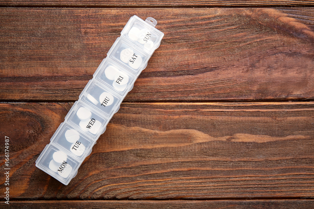 Health care concept. Plastic container with pills on wooden background