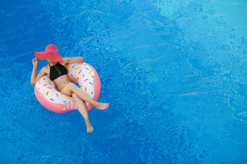 Sticker - Beautiful young woman and inflatable donut in blue swimming pool