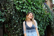 © shurkin_son - Outdoor lifestyle picture of happy relaxed young Caucasian blonde female student in transparent dress and earrings having cheerful pleased look, spending free time after college in urban park