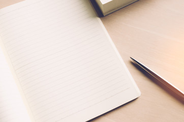 Wall Mural - Copy space of notebook pen and book with window light on wood table background.