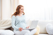© LIGHTFIELD STUDIOS - attractive pregnant woman shopping online with credit card and laptop at home