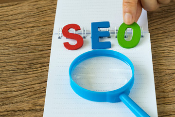 Aufkleber - seo search engine optimisation concept as hand holding colorful alphabet abbreviation seo with magni