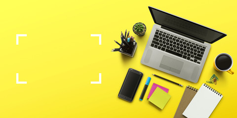 office workplace with laptop, notebook, office supplies and stationery on yellow background. solutio