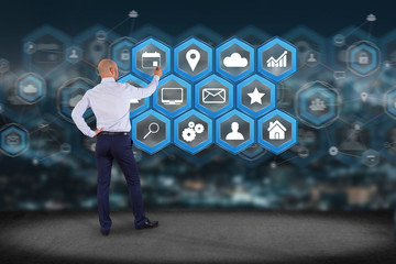 Poster - businessman in front of a wall with application center displayed on a futuristic interface with tech