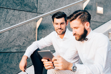 two bearded business men young outdoor using tablet - remote working, finance, business concept