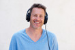 © mimagephotos - Close up cheerful man with headphones listening to music