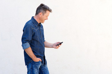 Handsome man smiling and walking with mobile phone