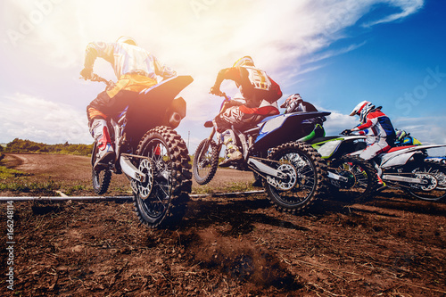 Fotografía team of athletes on mountain bikes starts, smoke and dust fly from under the wheels cross-country