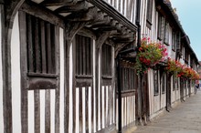Traditional Tudor Timber Framed Wattle And Daub Houses With Pretty Hanging Baskets