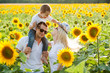 A happy family plays in sunflowers.