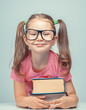 © Myst - smiling beautiful cute little girl leaning on thick books while looking at camera