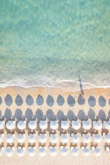 Sticker - View from above, stunning aerial view of an amazing white beach with white beach umbrellas and turquoise clear water during the sunset. Mediterranean sea, Sardinia, Italy.