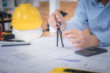 Architect or planner working on drawings for construction plans at a table