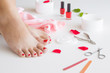Cares about woman's foot skin and nails. Pedicure beauty salon. Scissors, nail file, red nail polish and skin cream on the white background.
