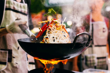 man cooks noodles on the fire