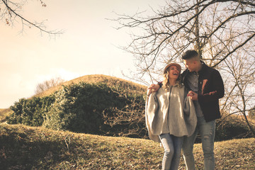 Happy coupe walking trough park in hug. Cheerful couple in nature.