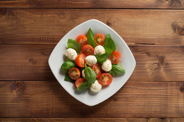 Canvas Print - caprese salad in plate at wood