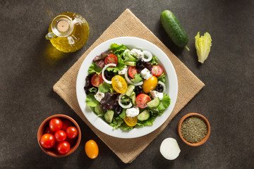 Canvas Print - fresh greek salad in plate and ingredients