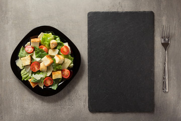 Wall Mural - caesar salad in plate at table