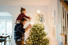 Father And Daughter Decorate A Christmas Tree