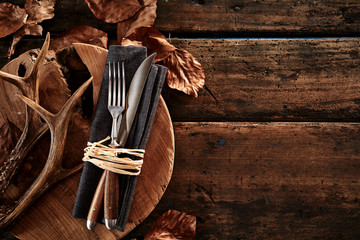Wall Mural - deer antlers with cutlery on wooden board