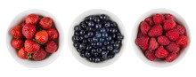 Row Of Bowls With Raspberries, Blueberries And Strawberries On White