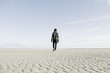 © Koen Meershoek/Stocksy - Hip young guy walking alone on the beach.