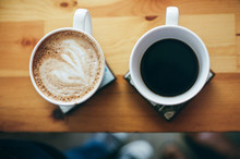 Overhead View Of Two Mugs Of Coffee On A Wooden Background.