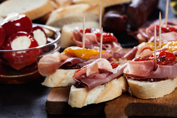 Sticker - Spanish tapas with slices jamon serrano and grilled pepper. Also olives, salami, pickled onions, and peppers stuffed with cheese