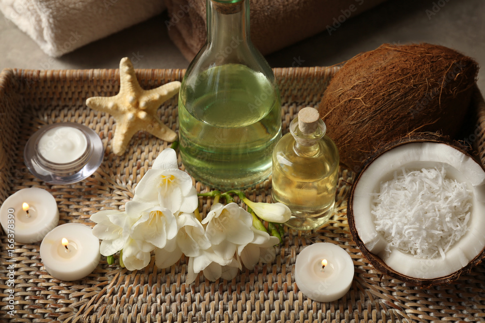 Tray with spa cosmetic, coconuts, flowers and candles