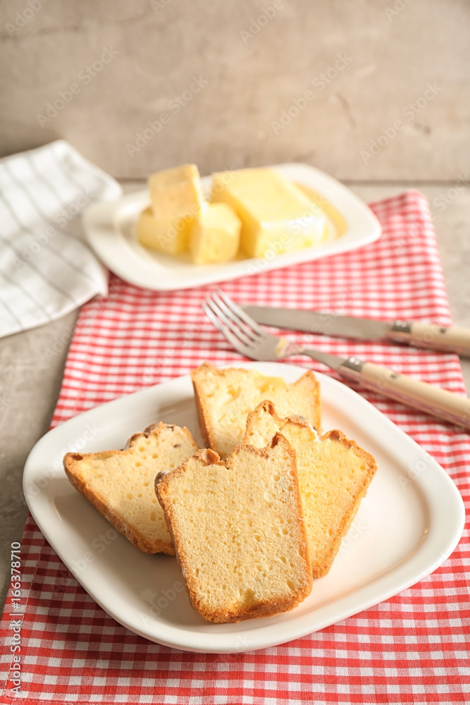 Plate with delicious sliced butter cake on table