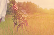 © Sviatoslav Kovtun - Girl in a field with a bunch of wild flowers in their hands. The concept of purity and unity with nature, sunlight