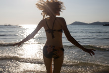 Woman In A Bikini Twirling On A Beach