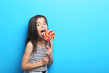 Beautiful Little Girl With Lollipop On Blue Background
