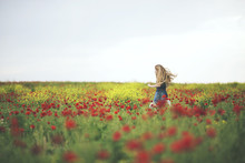 Happy Girl Running In Poppy Field