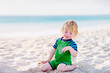 © Angela Lumsden/Stocksy - Toddler with a mouth full of sand after a face plant at the beach in summer