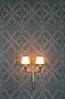 © Tomas Mikula/Stocksy - Vintage wall lamp with texture background