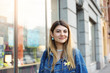 © shurkin_son - Style and fashion. Urban shot of beautiful charming young female with blond hair dressed in trendy denim jacket while shopping in city center, looking and smiling at camera, enjoying leisure time