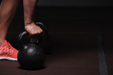 male adult exercising with kettle bell in gym