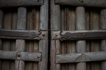 Ancient wooden gate with metal ornaments close