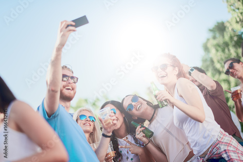 Plakat Przyjaciele bierze selfie przy plenerowym przyjęciem, światło słoneczne przy tłem