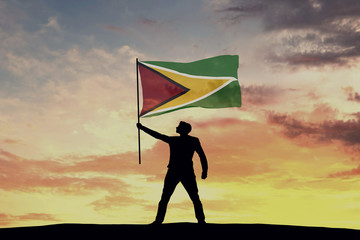 Canvas Print - Male silhouette figure waving Guyana flag. 3D Rendering