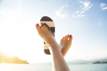Relaxed Woman Feet And Flip Flops On The Beach